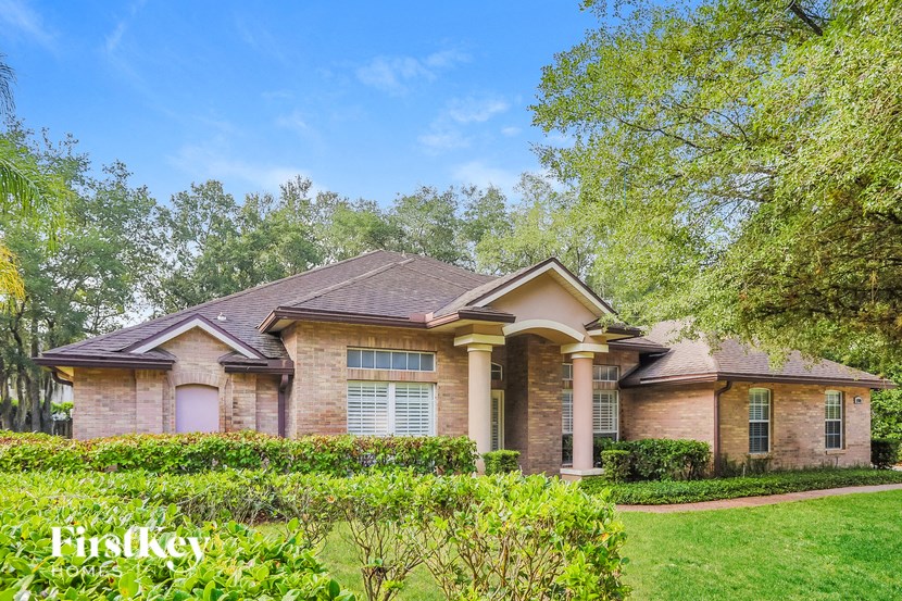 a house with a lawn and trees in front of it