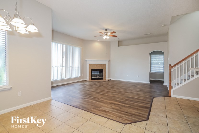 the living room and dining room with the staircase to the second floor