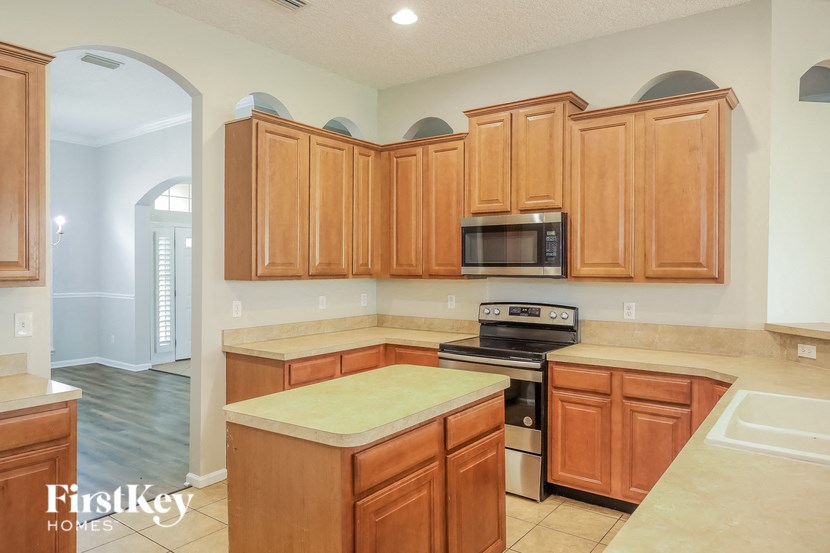 a kitchen with wooden cabinets and a stove and a microwave