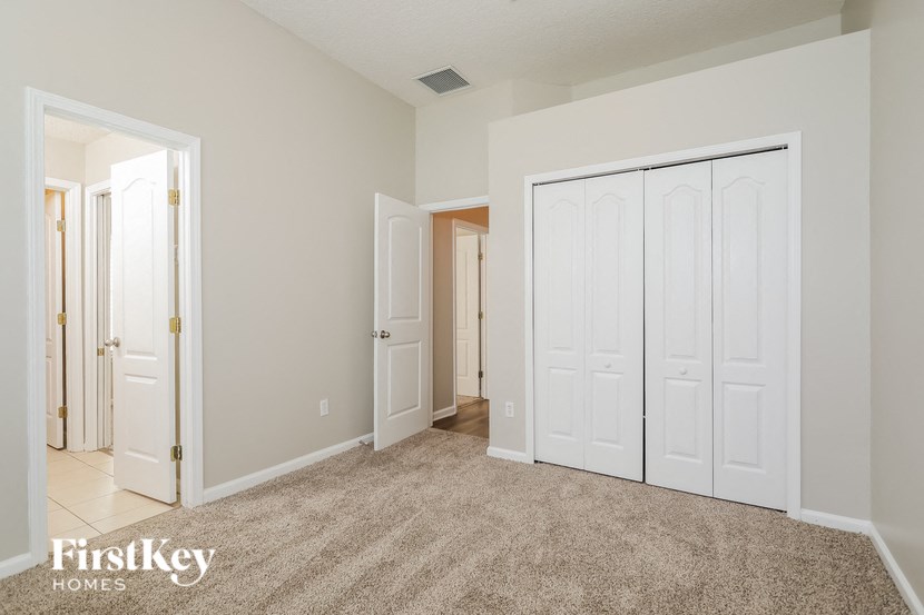 a bedroom with two closets and a carpeted floor