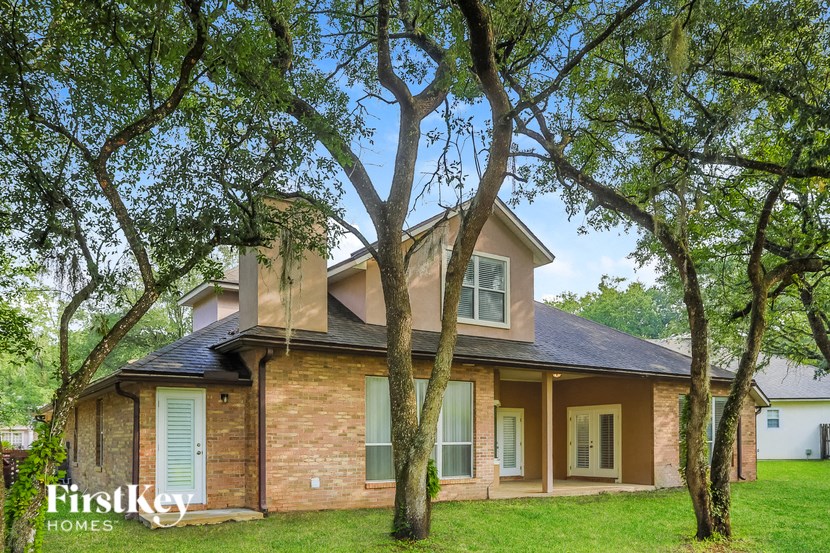 a brick house with trees in front of it