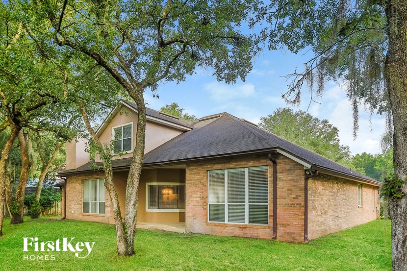 a brick house with a tree in the yard