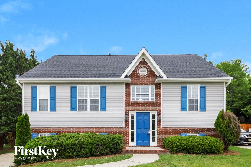 A house with a blue door and windows is for sale by FirstKey Homes.