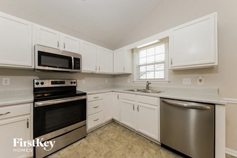 A kitchen with white cabinets and a stainless steel dishwasher.
