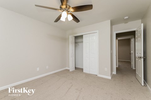 A room with a ceiling fan and a carpeted floor.