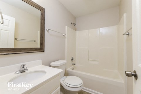A white bathroom with a toilet, sink, and bathtub.