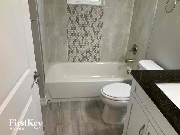 a bathroom with a toilet and a bath tub