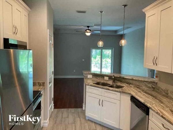 a kitchen with white cabinets and a stainless steel refrigerator