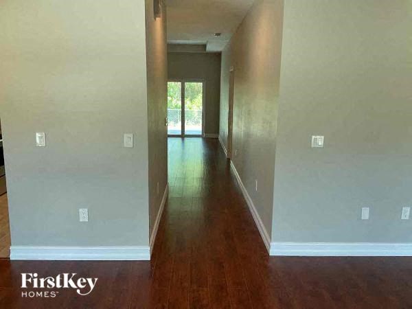 a long hallway with a wood floor and a door