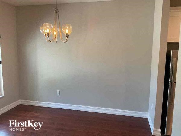 a empty room with a chandelier and a refrigerator