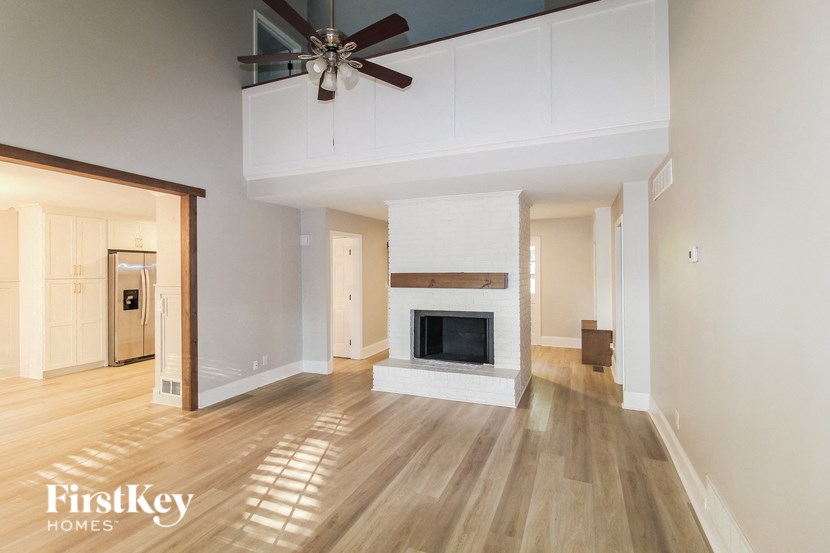a living room with a fireplace and a ceiling fan