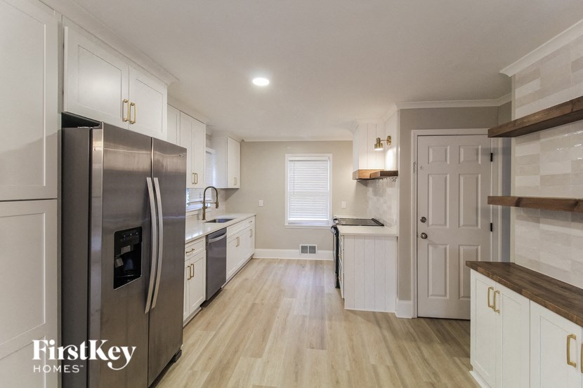 a large kitchen with white cabinets and stainless steel appliances