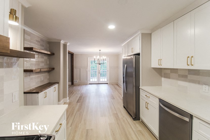 an open kitchen with white cabinets and stainless steel appliances