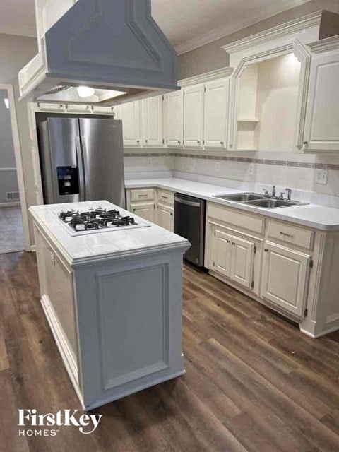 an updated kitchen with white cabinets and stainless steel appliances