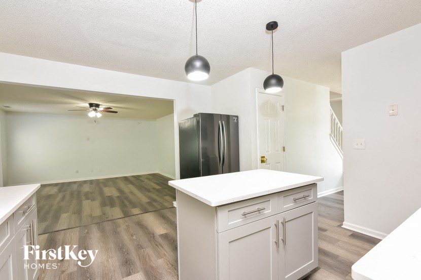an empty kitchen with white cabinets and a stainless steel refrigerator