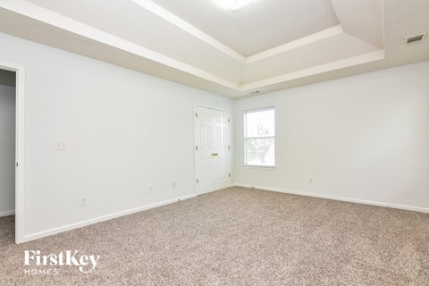 the living room of a home with carpet and a door