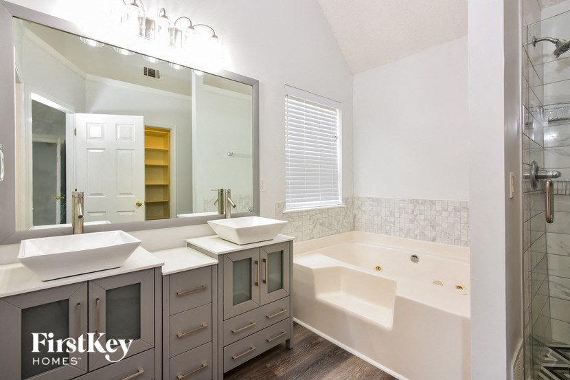 a bathroom with two sinks and a tub and a mirror