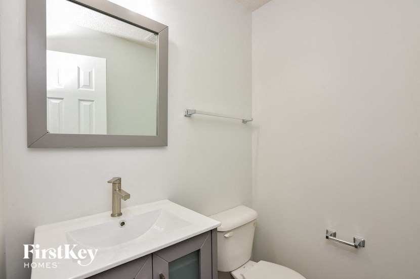 a bathroom with a toilet and a sink and a mirror