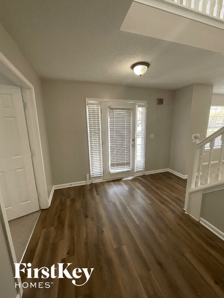 an empty living room with hardwood floors and a staircase