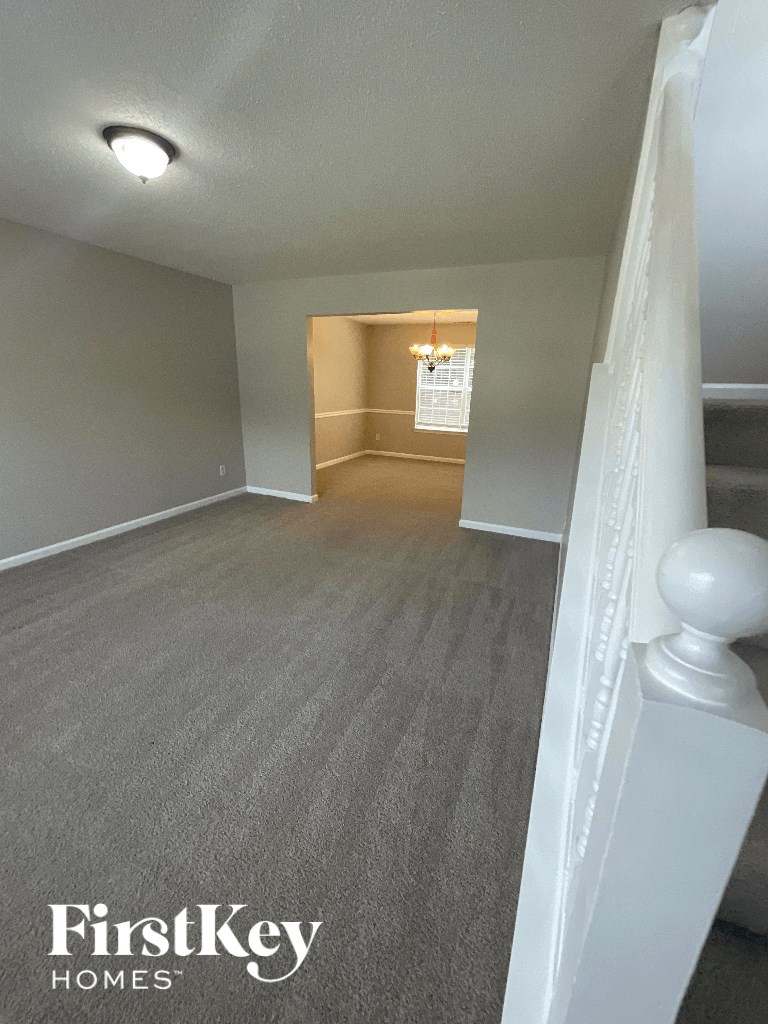 the view from the top of the stairs looking into the living room and dining room