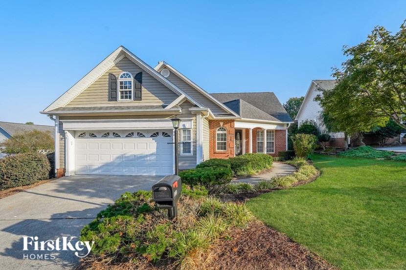 A house with a garage and a mailbox is for sale.