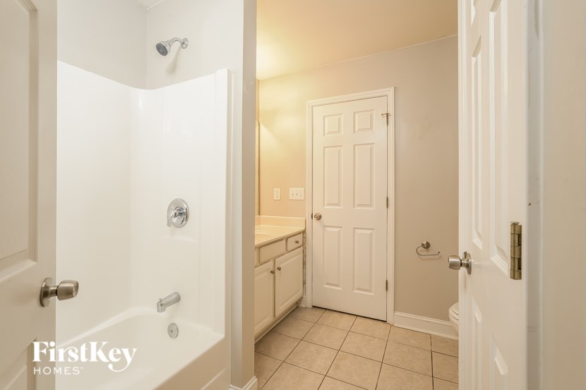 A white bathroom with a walk in shower and a toilet.