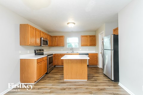A kitchen with wooden cabinets and a refrigerator.