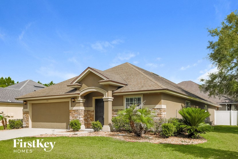 A house with a brown roof and a white fence.