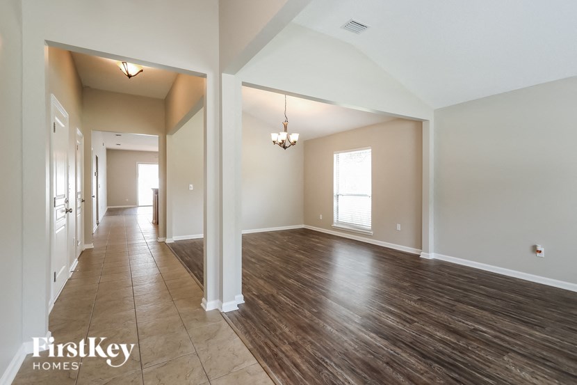 A spacious room with wooden floors and white walls.