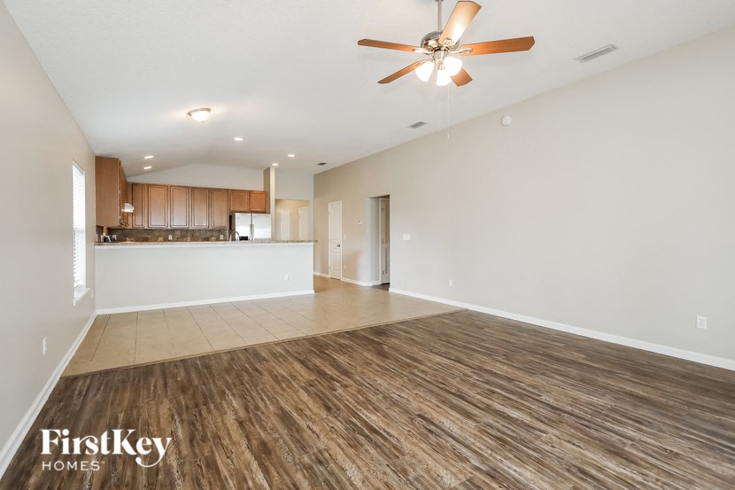 A spacious room with wooden flooring and a ceiling fan.