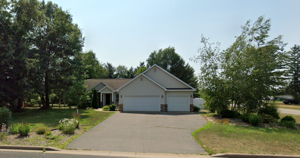 A house with a driveway and garage in front of it.