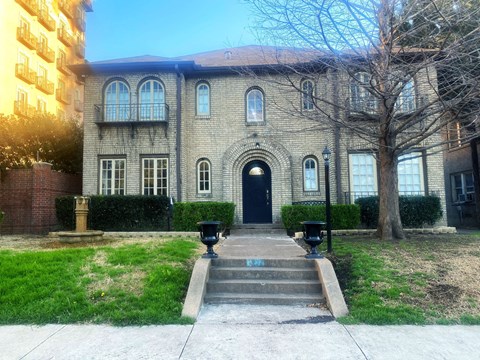 a large brick building with a black door and stairs