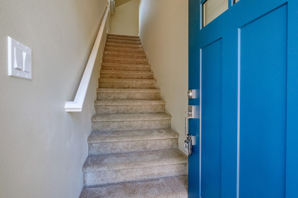 a set of stairs with a blue door at the bottom of the stairs