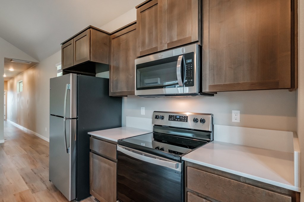 an updated kitchen with stainless steel appliances and wooden cabinets