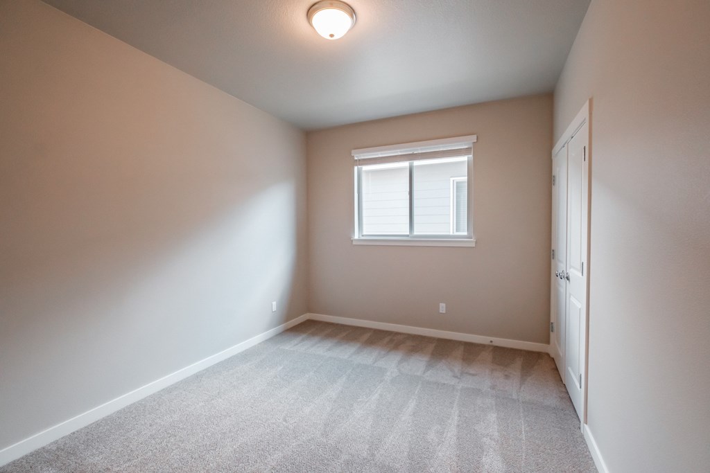 an empty room with a window and a door