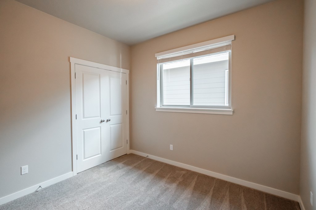 an empty room with a window and a door