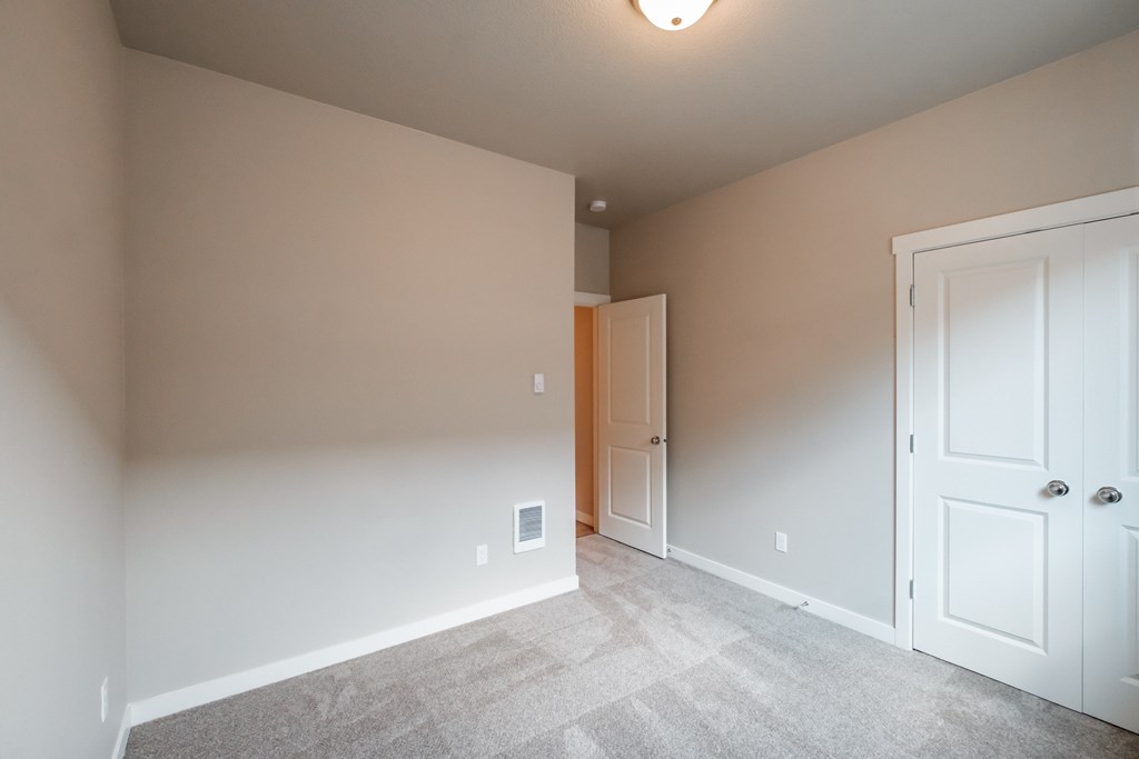 a bedroom with a closet and a door to a hallway