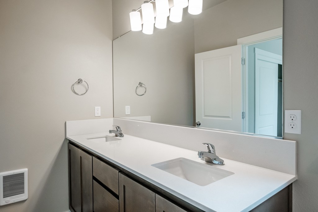 an empty bathroom with two sinks and a large mirror