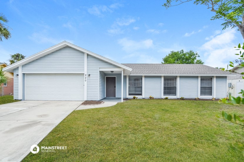 a blue and white house with a lawn and a driveway