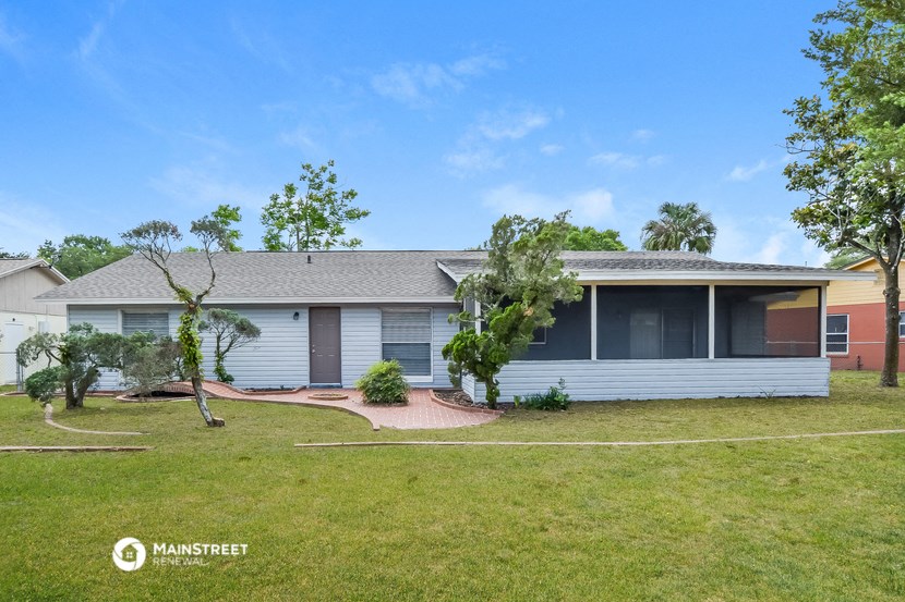 a white house with a lawn and trees in front of it