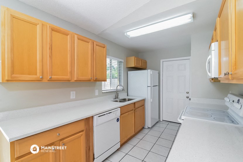 a kitchen with white appliances and wooden cabinets