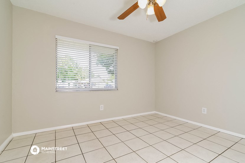 the living room has a large window and a tiled floor