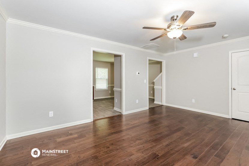 the living room with hardwood floors and a ceiling fan