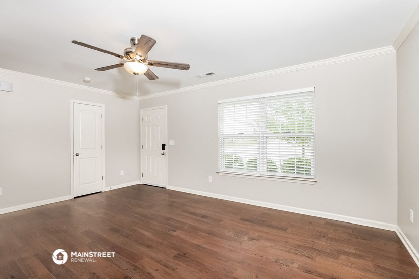 a living room with a ceiling fan and a window