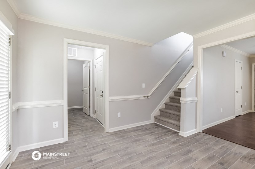 the living room and entryway with stairs to the second floor