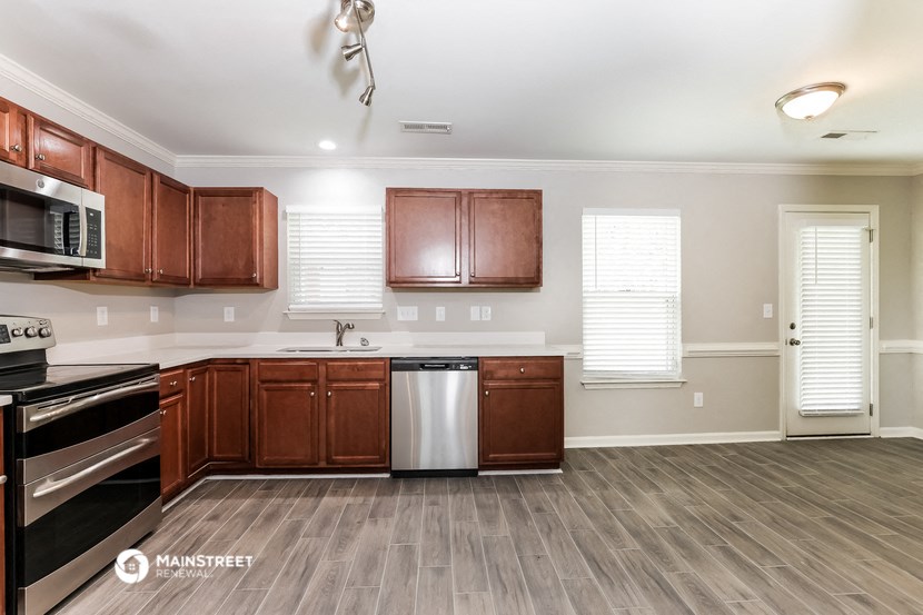 a kitchen with wood flooring and wooden cabinets