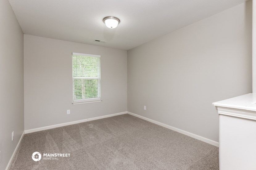 the upstairs bedroom with carpet and a large window
