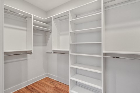A white closet with shelves and hanging space.