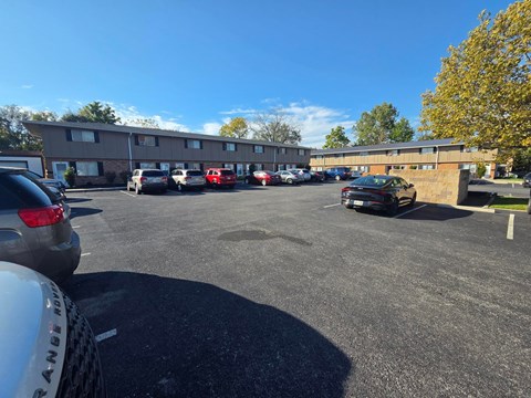 A parking lot with cars and a building in the background.