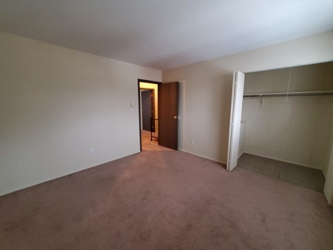 A room with a brown door and a white wall.